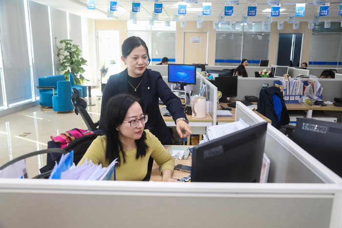 张熙与同事交流。记者 姚皓 摄