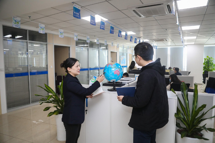 张熙与同事交流。记者 姚皓 摄