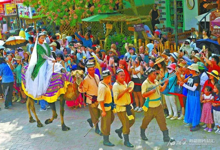 7月5日，游客在喀什古城景区欣赏“丝路驼队”巡游。阿地力江·阿不都卡德尔摄