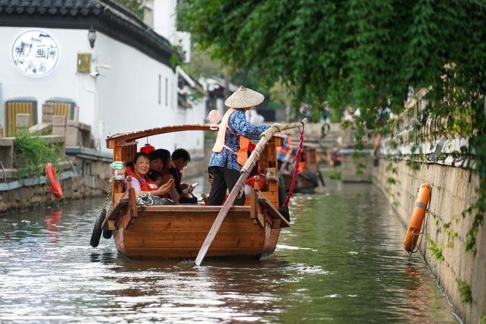 游客乘船在苏州平江历史文化街区休闲游玩（2023年7月3日摄）。新华社记者 李博 摄