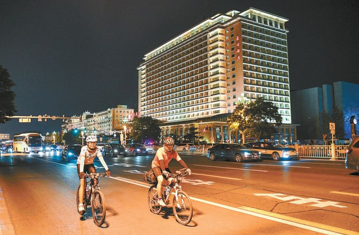 入夜后，骑行爱好者在东长安街王府井路段骑行。 本报记者 邓伟摄