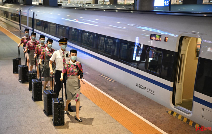 ▲完成此次执乘任务的列车长刘玉蛟（右）和班组成员