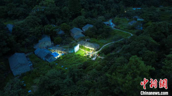 电影发出的光点亮了村庄。（无人机照片）章毅 摄