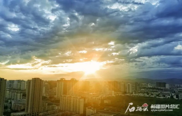 7月11日清晨，乌鲁木齐市天气多云，太阳从云层中透射出金色的光芒。石榴云/新疆日报记者 杨伟 摄