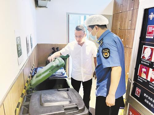     近日，廊坊城管执法人员（右）深入万向城餐饮门店宣传检查垃圾分类工作。 河北日报通讯员 段贵争摄