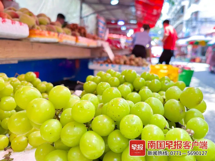7月13日中午，市民在南宁市官塘菜市买葡萄。