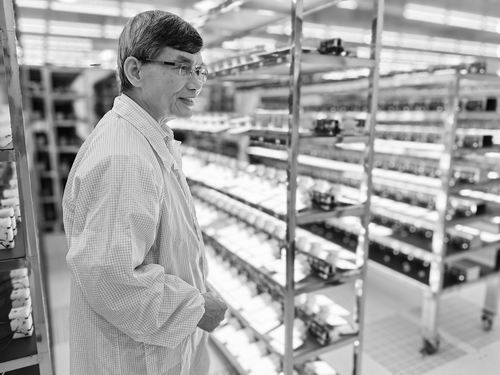 ▲廖良生在OLED发光面板产品老化测试车间。