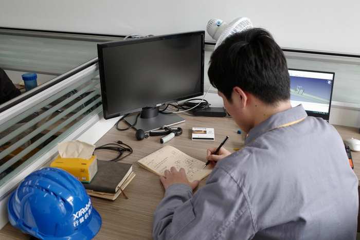 张富强在画图分析机器人切割轨迹。新华社记者 栾若卉 摄