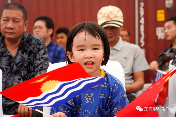 ▲当地华侨小朋友挥舞中基两国国旗欢迎“和平方舟”号医院船来访。黎宇摄