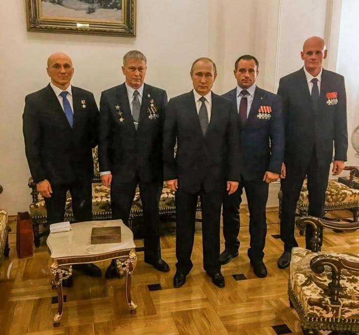 ▲特罗舍夫（左二）和乌特金（右一）佩戴勋章与俄总统普京合影