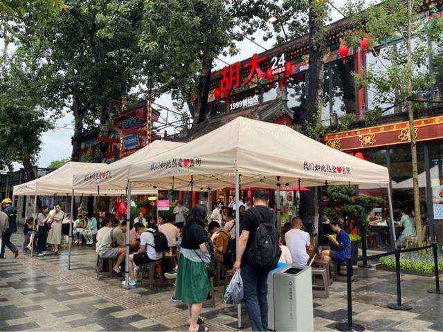 7月13日傍晚，胡大总店门口坐满了等位的顾客。实习生 宋婧 摄