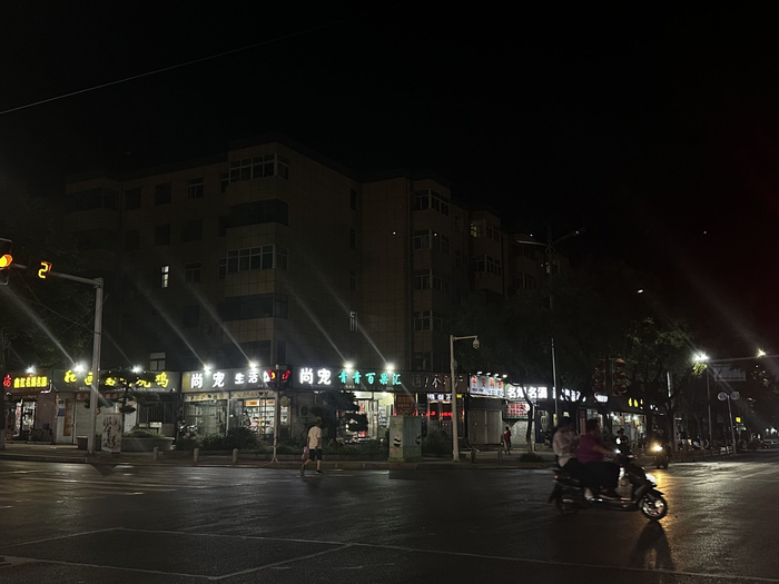 夜晚，路边仅有一楼的商铺亮着灯，楼上的居民楼无人居住。时代财经王莹岭摄