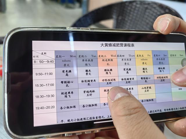 6月15日，大黄蜂减肥营教练为记者介绍减肥营的课程表，每天训练时间为4个半小时。  新京报记者 刘思维 摄