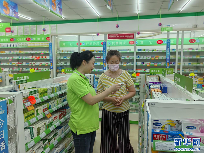 国药控股国大药房沈阳连锁有限公司药店，执业药师在为顾客进行用药指导（受访单位供图）