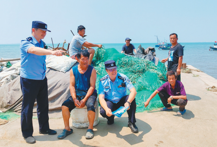 民警向当地渔民进行普法宣传。 记者 丁思文 摄