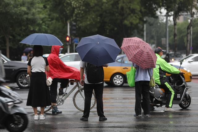 7月21日早晨，知春路，市民行走在小雨中。新京报记者 浦峰 摄