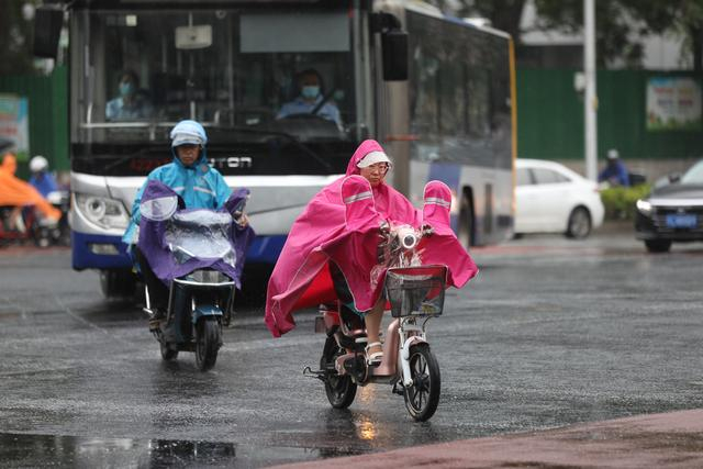 7月21日早晨，中关村东路，市民骑行在小雨中。新京报记者 浦峰 摄