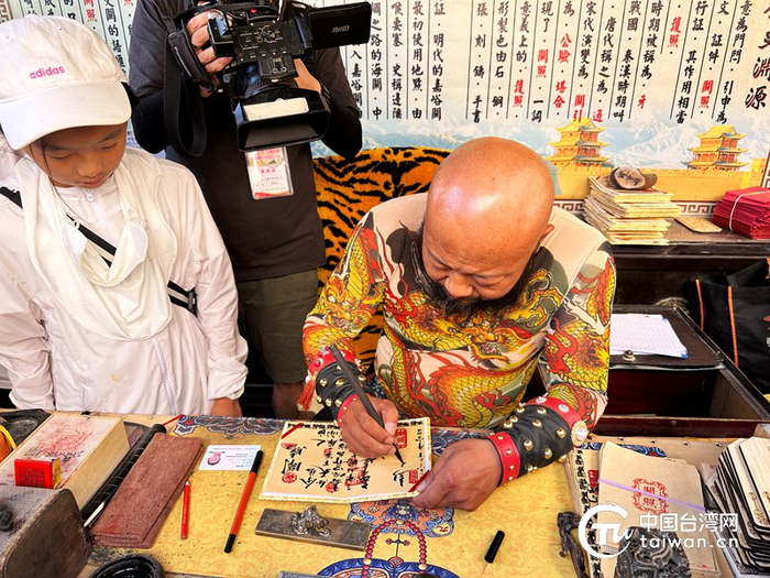 嘉峪关“网红”关长正在“关照”上书写通关“谜语”。（中国台湾网 李柏涛 摄）