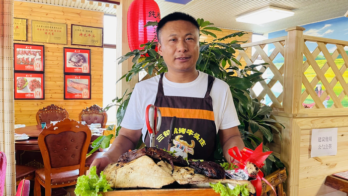 朱景峰是大庆第一个做坑烤牛头的商户