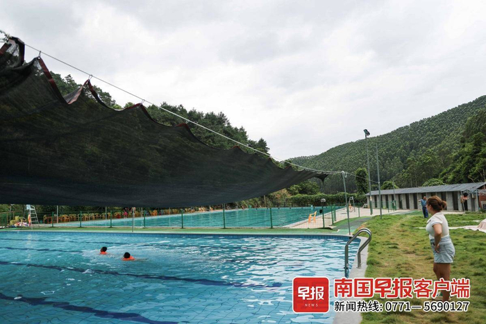 桂平市西山镇的绿河山水农庄游泳池，家长带着两名孩子在游泳。记者 游拥军 实习生 覃安桐 摄