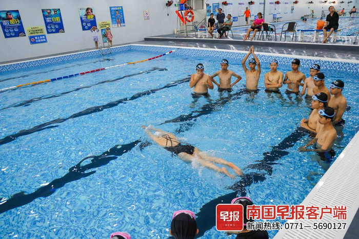 桂平市木根镇木根初中游泳培训基地（泉塘游泳馆）中，游泳教练正在教孩子们学习游泳知识。记者 游拥军 实习生 覃安桐 摄