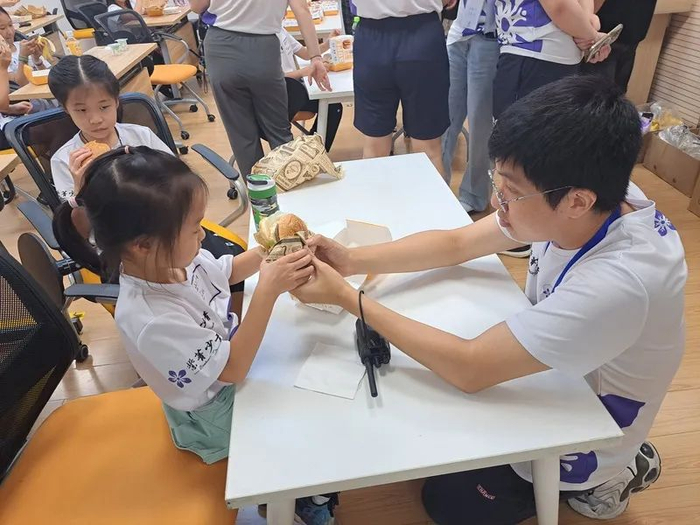 图为唐品恒与香港孩童交流。