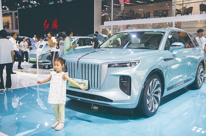 小朋友在红旗E-HS9车前摆造型拍照。