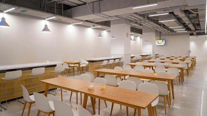 整个就餐空间结合快手橙白品牌色，采用简约的日系原木色餐桌椅，设计线条流畅，用餐氛围温馨舒适，全面呈现美好就餐场景。