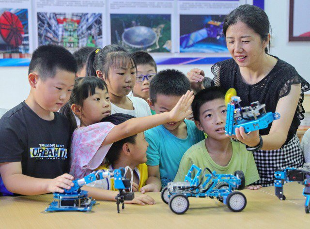 科普教师为小朋友讲解机器人结构及传感器工作原理   曹建雄 摄