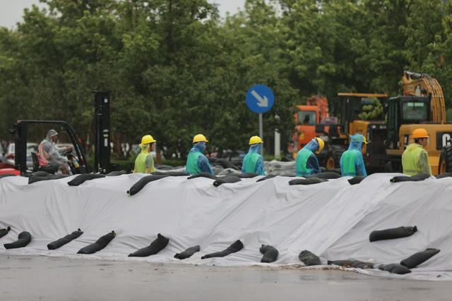 工人在堤坝前执勤。新京报记者 王子诚 摄