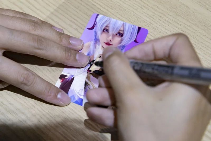 张欣羽为粉丝在照片上签名。