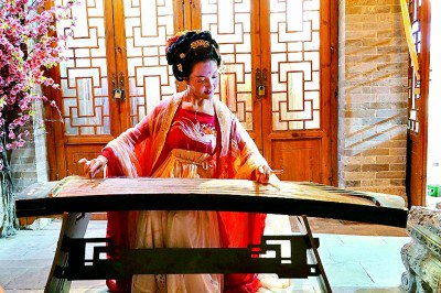     悠扬的琴声从穿汉服的女孩指尖滑出，氤氲在整个古城。本报记者 毕玉才摄