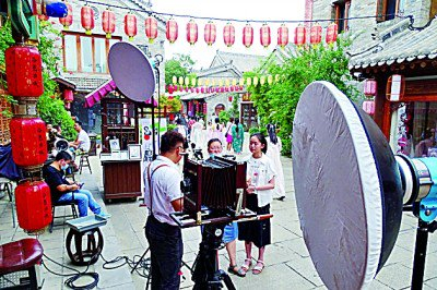     洛邑古城一照相馆店主给游客讲解胶片座机拍摄原理、操作流程和后期制作。刘晓光摄