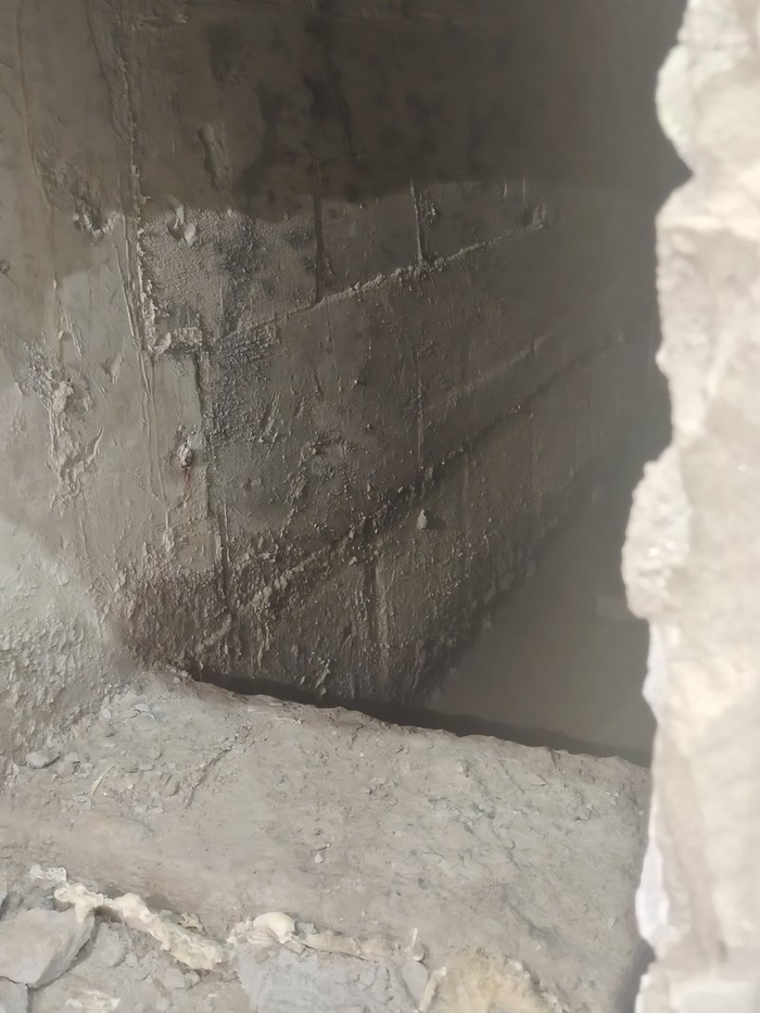 △一处电梯旁边的地砖呈掀开状态，坑里有约5厘米深积水。