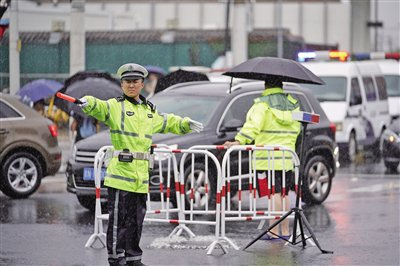 7月30日，十里河桥下，路口中央的一处井盖正在喷涌，交警现场疏导交通。新京报记者 王贵彬 摄