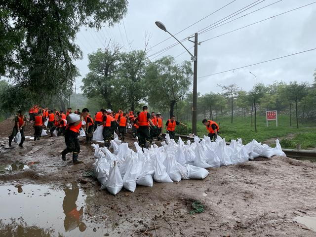 2023年8月1日，北京市门头沟区京原漫水桥，武警北京总队官兵正在装填、搬运用于筑堤坝的沙袋。新京报记者 张静姝 摄
