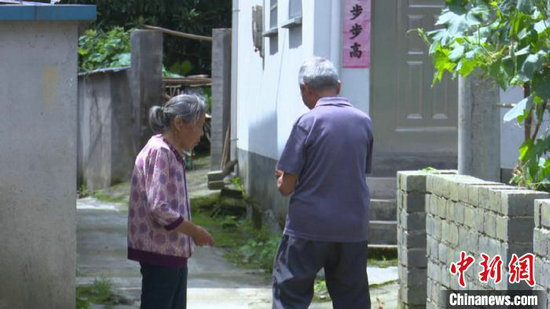 留守老人的门锁坏了，汪锡熊前去帮老人修门锁。刘鸿鹤 摄