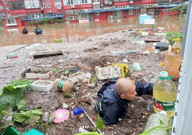 首开天岳恒公司紫玉分公司原子能项目部工作人员正冒雨在水中疏通排水管道。企业供图