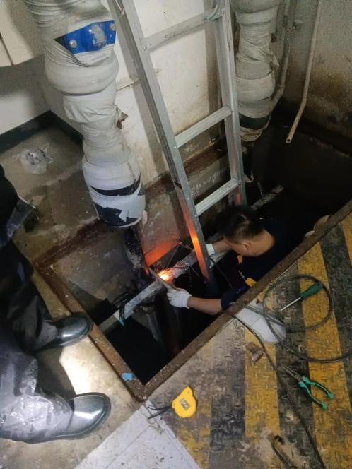 门头沟区上悦嘉园项目物业工作人员冒雨疏通地下管道。企业供图