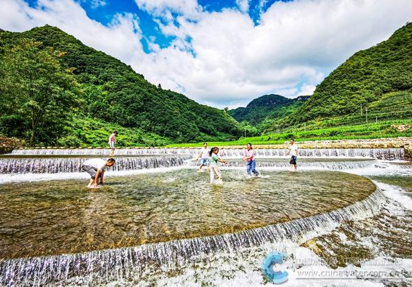 人们在拦河堰戏水游玩