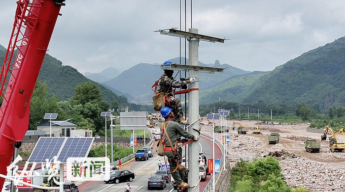 8月1日，国网武安市供电公司抗洪抢险党员突击队队员在国道G234兴阳线活水村段抢修电路。 河北日报通讯员李树锋摄