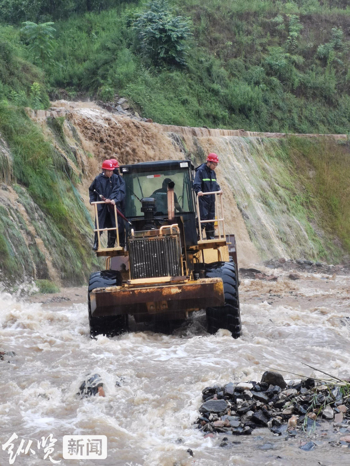 7 月30日，因暴雨冲刷，道路坍塌，国网武安市供电公司工作人员克服困难，乘坐铲车前往古武当山地区进行电力抢修。徐建锋 摄