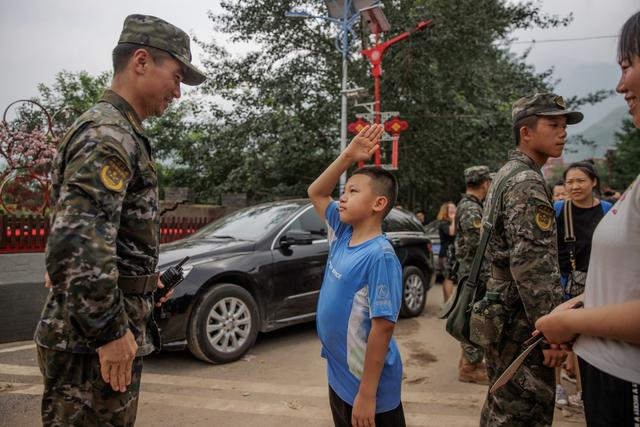 8月2日，妙峰山镇，一位即将登车离开的小朋友武天骐向武警北京总队官兵敬礼，对一路过来的照顾表达感谢。新京报记者 王子诚 摄