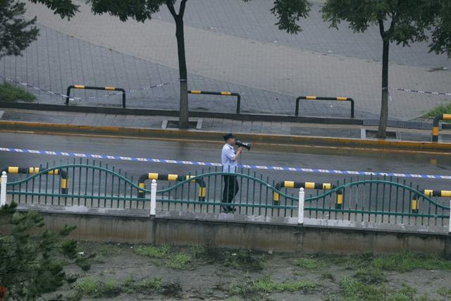 8月1日，冬奥公园河堤上，执勤人员引导市民快速通过。新京报记者 浦峰 摄