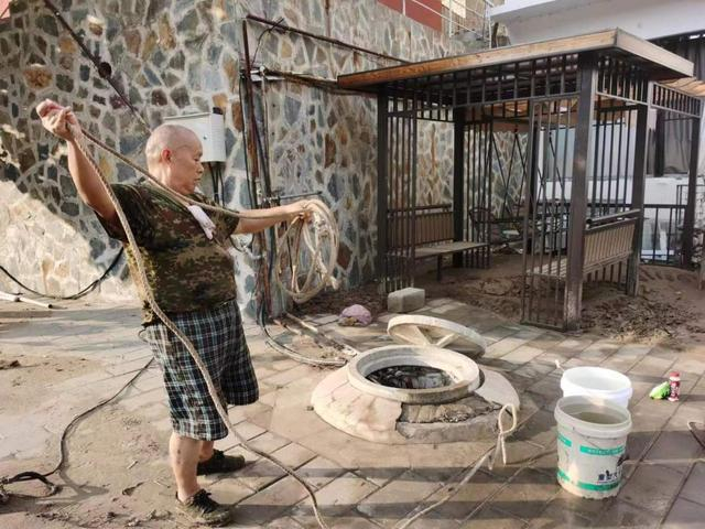 邢各庄村目前仍然断水断电。村民们正在打井水，而几天前他们只能用桶接雨水饮用。 雷册渊 摄