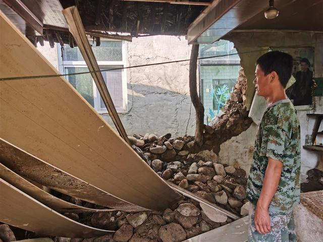 7月30日，李万平家的老屋在暴雨中垮塌，垮塌前他接出了73岁的老母亲。 雷册渊 摄