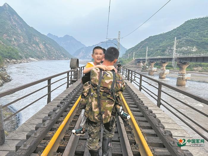     8月2日，Z180次受困列车的旅客在武警部队官兵的帮助下前往转运客车。新华社记者 王艳刚摄 