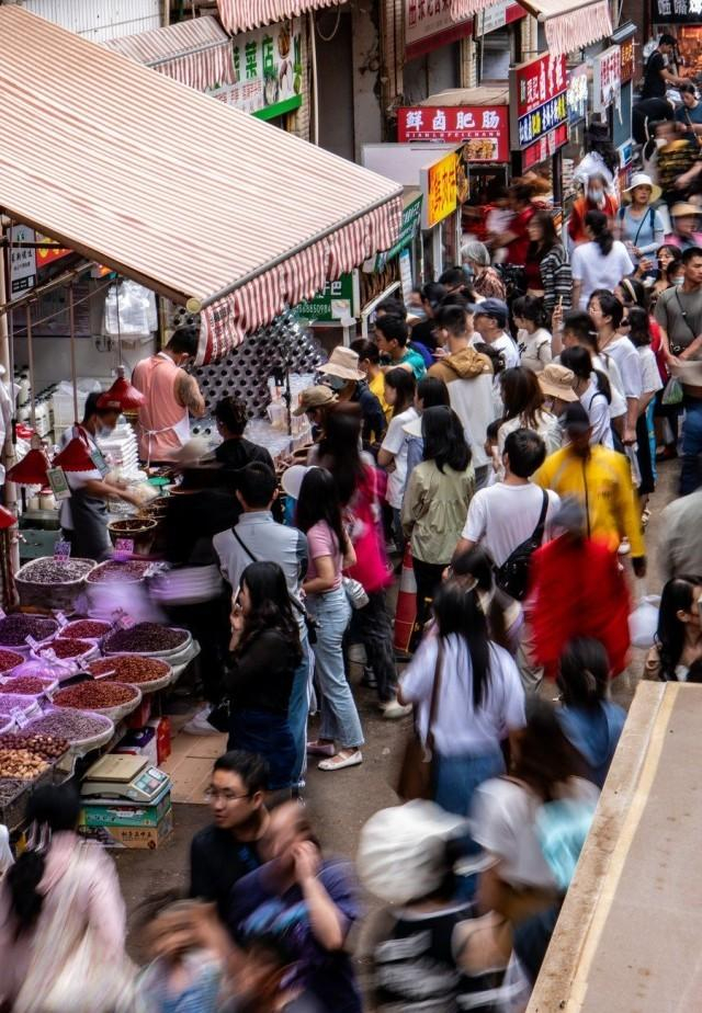 游客在昆明市大观篆新农贸市场排队购买“网红小吃”（7月27日摄）。新华社记者 江文耀 摄