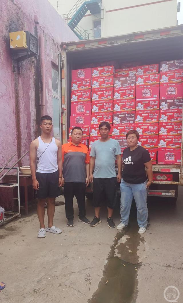 ▲8月3日，岳建设和岳旭在运送物资时的合影，左一为岳旭，左三为岳建设。 图片来源/受访者供图