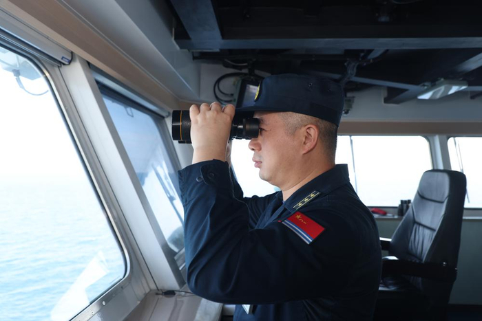　　海上训练中，中国自主研制的首艘两栖攻击舰海南舰舰长张美玉观察海空态势（2月23日摄）。新华社发（乔晨曦 摄）